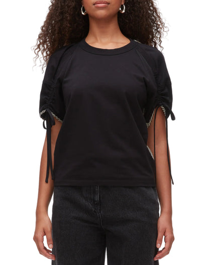 A person wearing the 3.1 Phillip Lim Ruched T-Shirt with Combo Panel Back and black jeans stands against a white background.