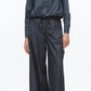 Wearing the 3.1 Phillip Lim Denim Cropped Shirt with a drawstring hem, tucked into high-waisted wide-leg jeans and styled with black shoes creates a modern silhouette.