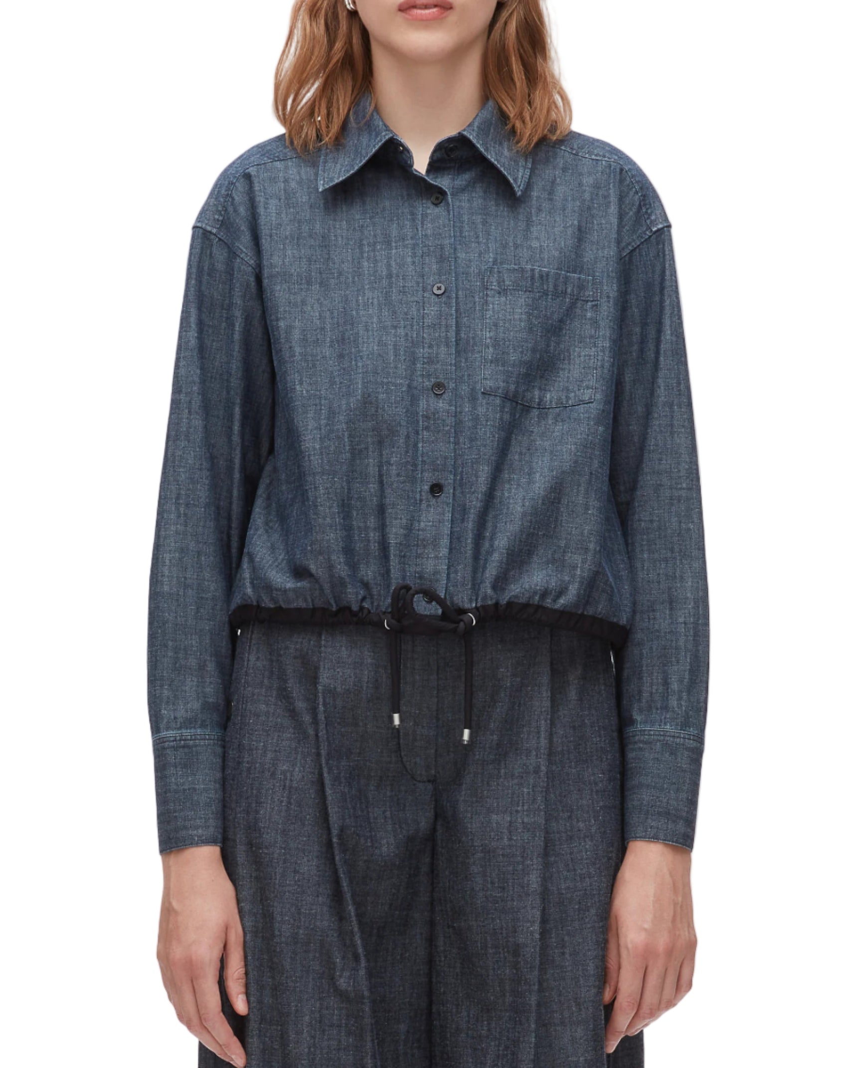 A person models the 3.1 Phillip Lim Denim Cropped Shirt, featuring a drawstring hem, paired with matching denim pants to showcase a modern silhouette against a plain background.