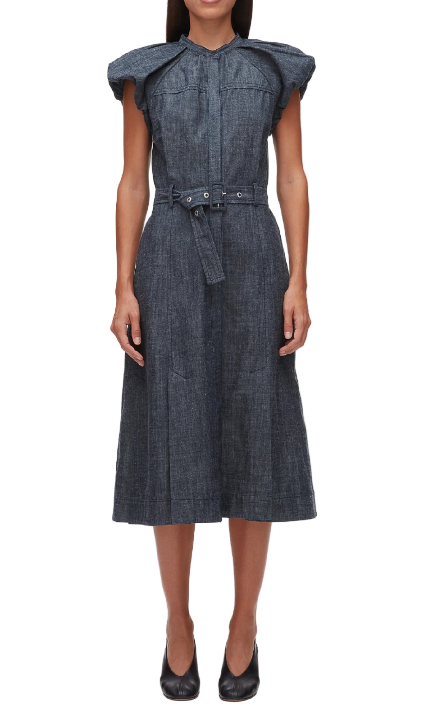 A woman models the 3.1 Phillip Lim Denim Puff Sleeve Dress, featuring a belted waist and romantic shoulders, paired with black heels against a white background.