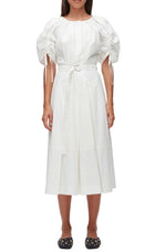 A woman wears the 3.1 Phillip Lim Ruched Sleeve Midi Dress with puffed short sleeves and a D-ring belt, styled with black studded flats, standing against a plain background.