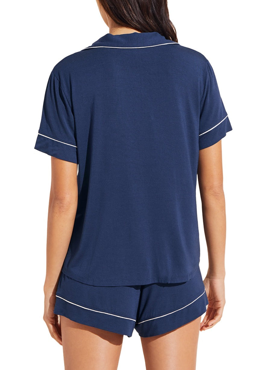 Person wearing the Eberjey Gisele Relaxed Short PJ Set in navy blue with white piping, crafted from luxurious knit fabric, viewed from the back.