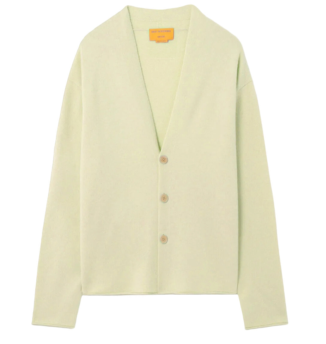 Guest in Residence Everywear Cardigan in light green, featuring a classic V-neckline and three brown front buttons, displayed flat on a white background.
