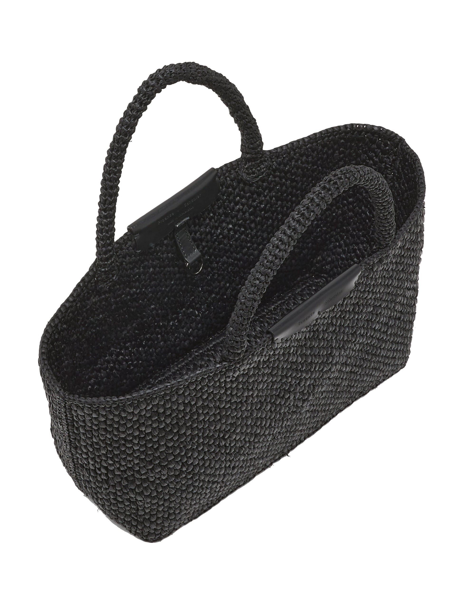 The East West Raffia Chelsea Tote by Proenza Schouler is shown empty in black, featuring two handles and photographed from an angled, overhead perspective—this sophisticated piece channels the refined silhouette of a structured handbag, seamlessly uniting practical design with contemporary style.