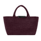 The Proenza Schouler East West Raffia Chelsea Tote features two handles and a rectangular black accent near the top opening, presented against a white background. This structured handbag combines timeless style with refined details for an elegant, polished appearance.