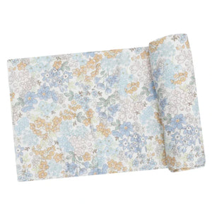 The Angel Dear Edith's Floral Swaddle Blanket is crafted from a soft and stretchy bamboo blend fabric, featuring a charming floral pattern in blue, yellow, and white. It's ideal for making cozy swaddles.