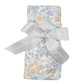 The Angel Dear Edith's Floral Swaddle Blanket, made from soft and stretchy bamboo fabric with a floral pattern, is neatly folded and tied with a gray ribbon bow, making it perfect for swaddling.