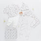 The Nesting Box Baby Take Home Set by Pink Chicken features two outfits, a hat, blanket, zippered bag, and teether in animal and stripe patterns—all made from soft organic pima cotton for the perfect neutral newborn gift.