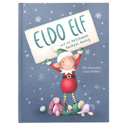 Book cover for "Jellycat Eldo Elf and the Patchwork Bashful Bunny Book" by Ella Hearnshaw and Lizzie Walkley. Features an illustrated Eldo Elf holding a sign with the title, surrounded by stuffed animals in a snowy, zero-waste setting.