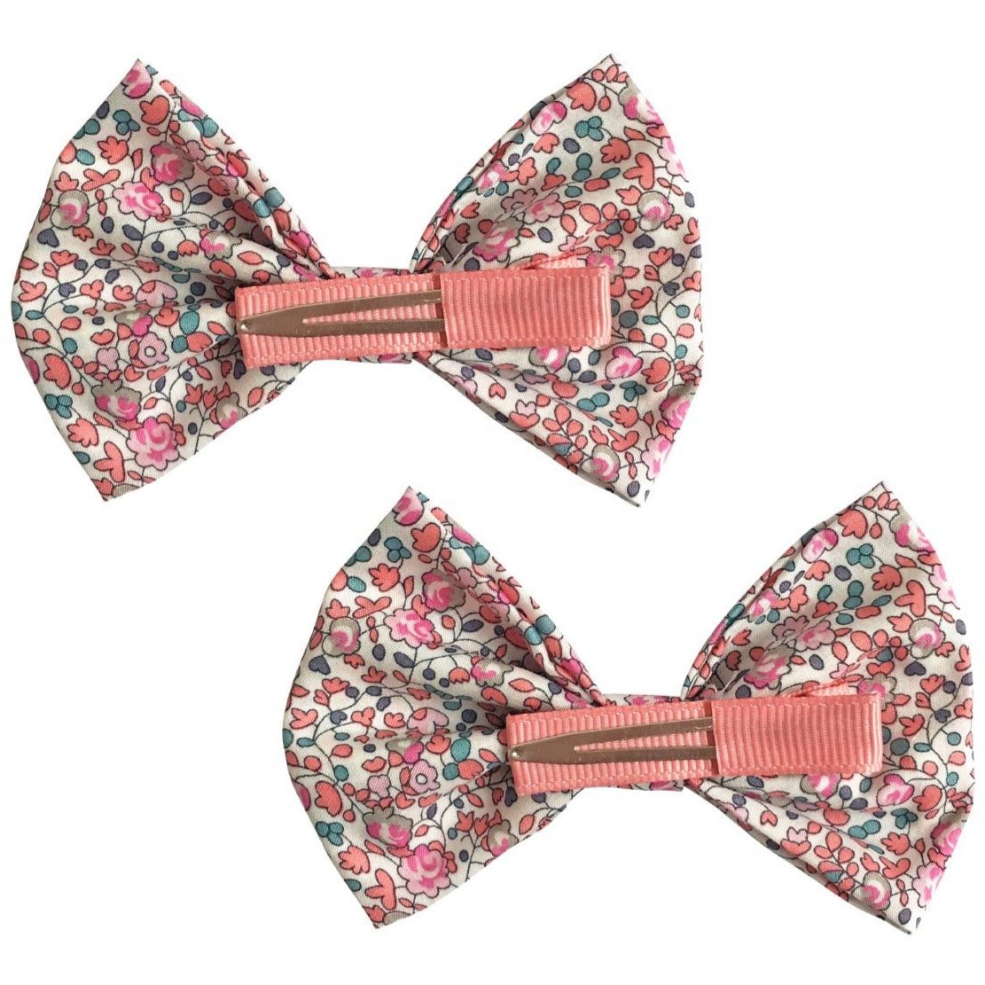 The Milledeux® Large Bowtie Bow Liberty Eloise C set includes two charming fabric hair bows with a delicate pink floral pattern, secured with nickel-free pink alligator clips, positioned side by side on a crisp white background.