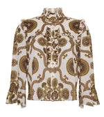 The Elowen Top by Cara Cara is a long-sleeved blouse featuring a ruffle collar, ruffled shoulders, and a brown and gold floral print on white.