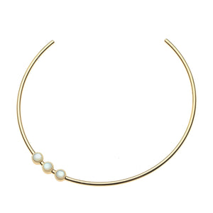 A gold Neck Cuff by Jane Win featuring three evenly spaced white pearls set in gold bezels on one side.