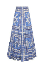 The Cara Cara Emilia Skirt is a long, voluminous piece with a blue and white tile pattern featuring floral and decorative details, plus two front pockets.
