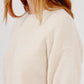 A cream-colored, relaxed-fit Sablyn Evie Sweater with a crew neck and elbow-length, short sleeves.