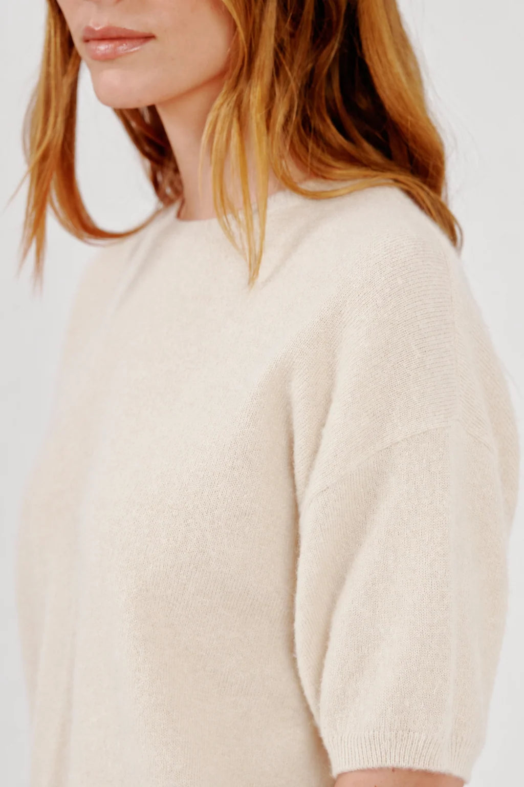 A cream-colored, relaxed-fit Sablyn Evie Sweater with a crew neck and elbow-length, short sleeves.