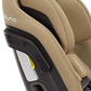 Close-up side view of a beige Nuna EXEC car seat with Slip Cover and 2nd Insert, prominently displaying the branding and a visible warning label. The seat also features an Aeroflex side impact protection system for enhanced safety.