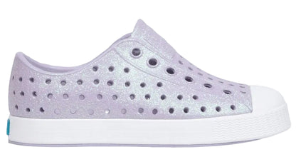 The Kids’ Jefferson Bio-Bling™ by Native Shoes features a lavender slip-on design with a biodegradable glitter finish, a perforated upper, and a lightweight white EVA rubber toe and sole.