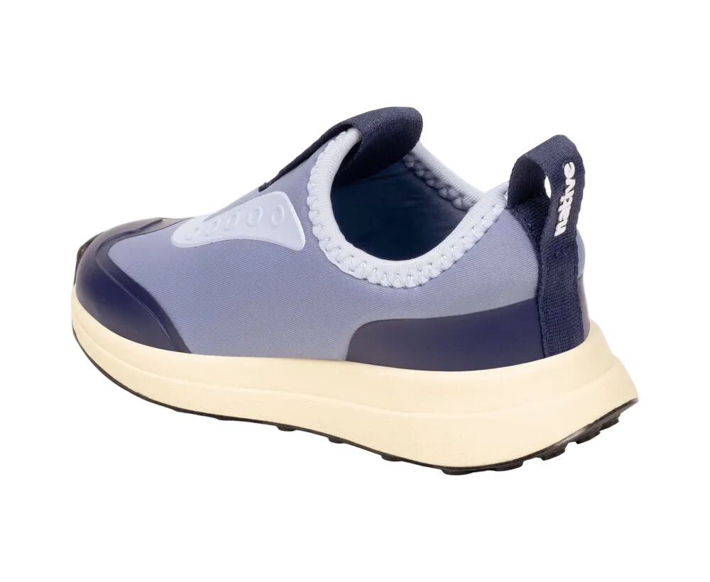 A single blue Kids’ Robbie Dash Sneaker by Native Shoes is displayed against a white background. Featuring a white sole, black outsole, and a convenient pull tab at the heel, this shoe is crafted with breathable mesh for all-day comfort and easy slip-on styling. It also includes a cushy midsole to support growing feet.