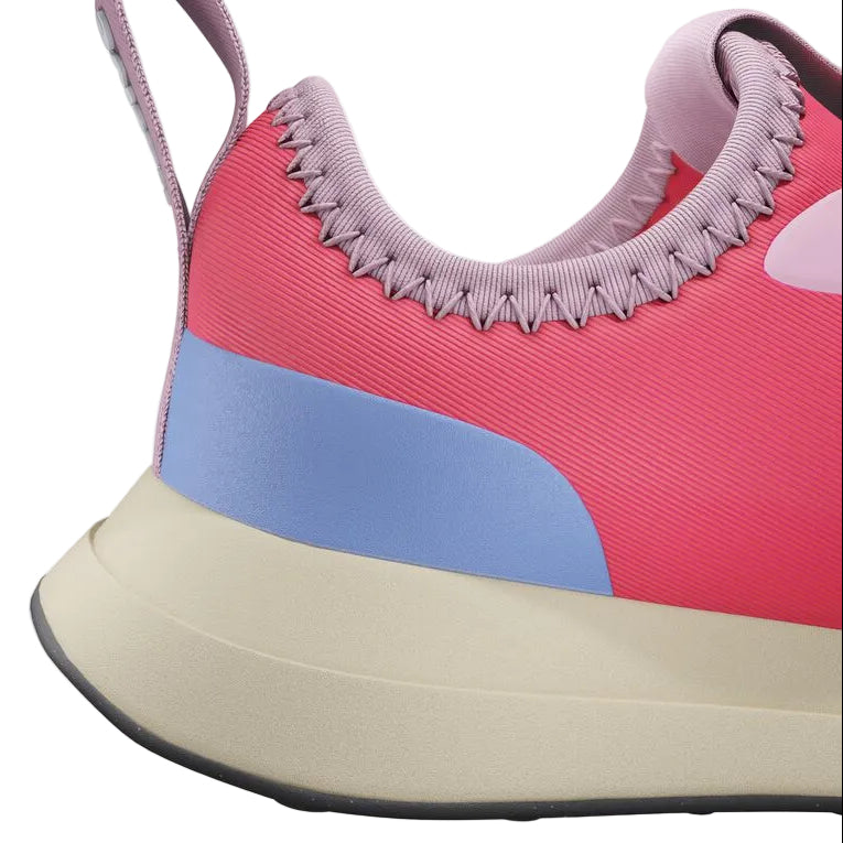 Close-up of the heel of the Kids’ Robbie Dash Sneakers by Native Shoes, showcasing pink, purple, and blue panels with a beige sole and a pink pull tab. The design incorporates breathable mesh for added comfort.