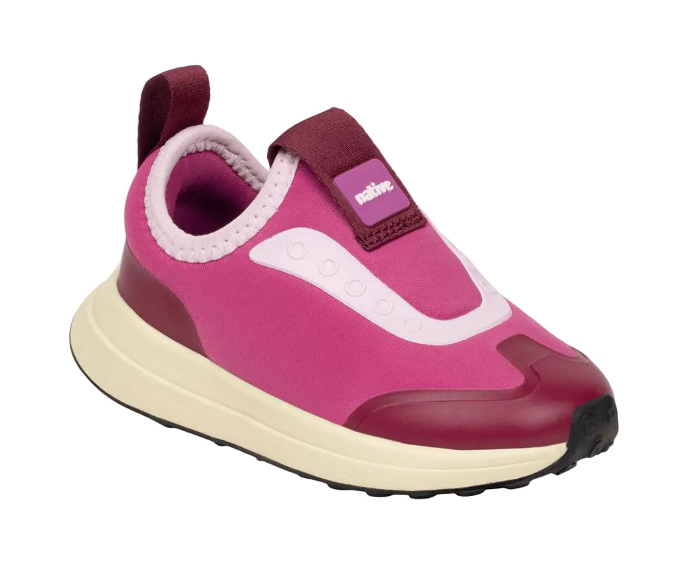The Kids’ Robbie Dash Sneakers by Native Shoes feature a pink and burgundy design with a breathable mesh upper, cushioned midsole, white sole, and convenient pull tab at the heel, shown against a white background.