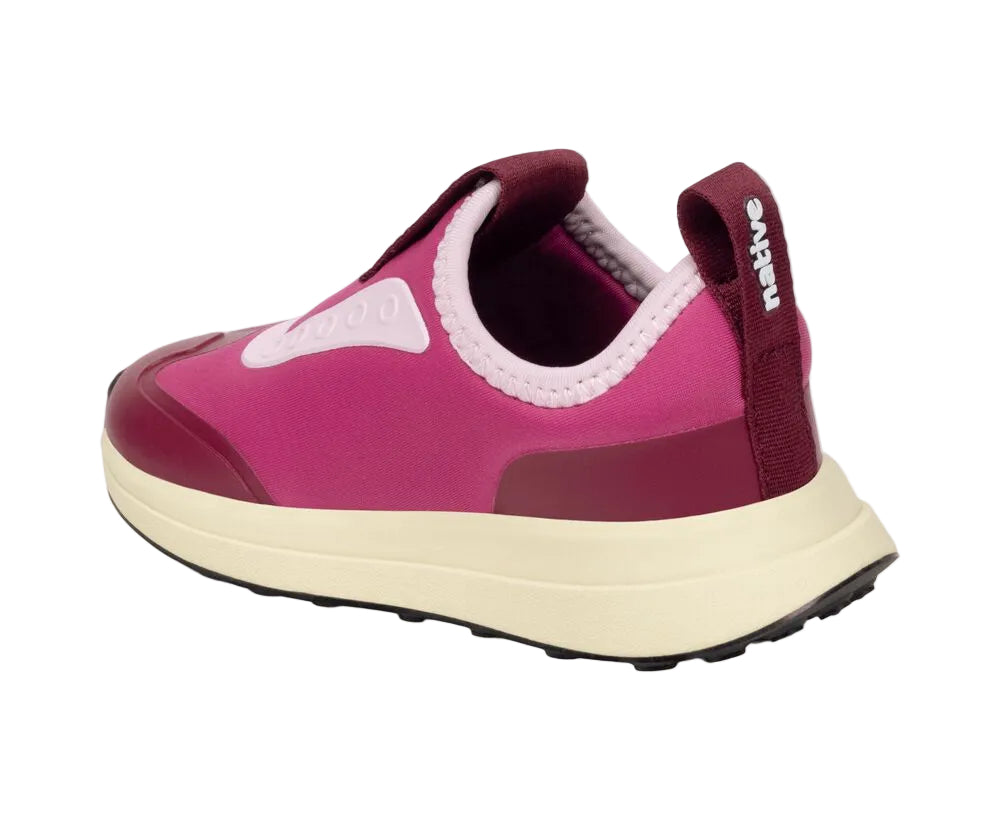 The Kids’ Robbie Dash Sneakers by Native Shoes are shown from a rear side angle against a plain white background, featuring a pink and maroon design with a breathable mesh upper and a white sole.