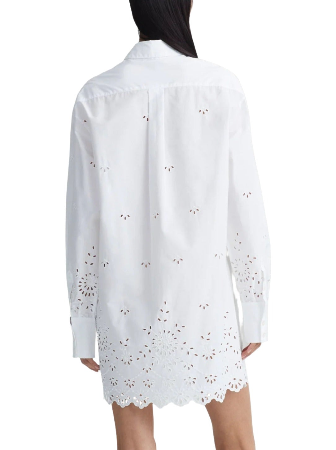 Back view of a person wearing the Altuzarra Morton Dress by Altuzarra, a white long-sleeve mini silhouette dress featuring eyelet embroidery and a scalloped hem, crafted from cotton-poplin.