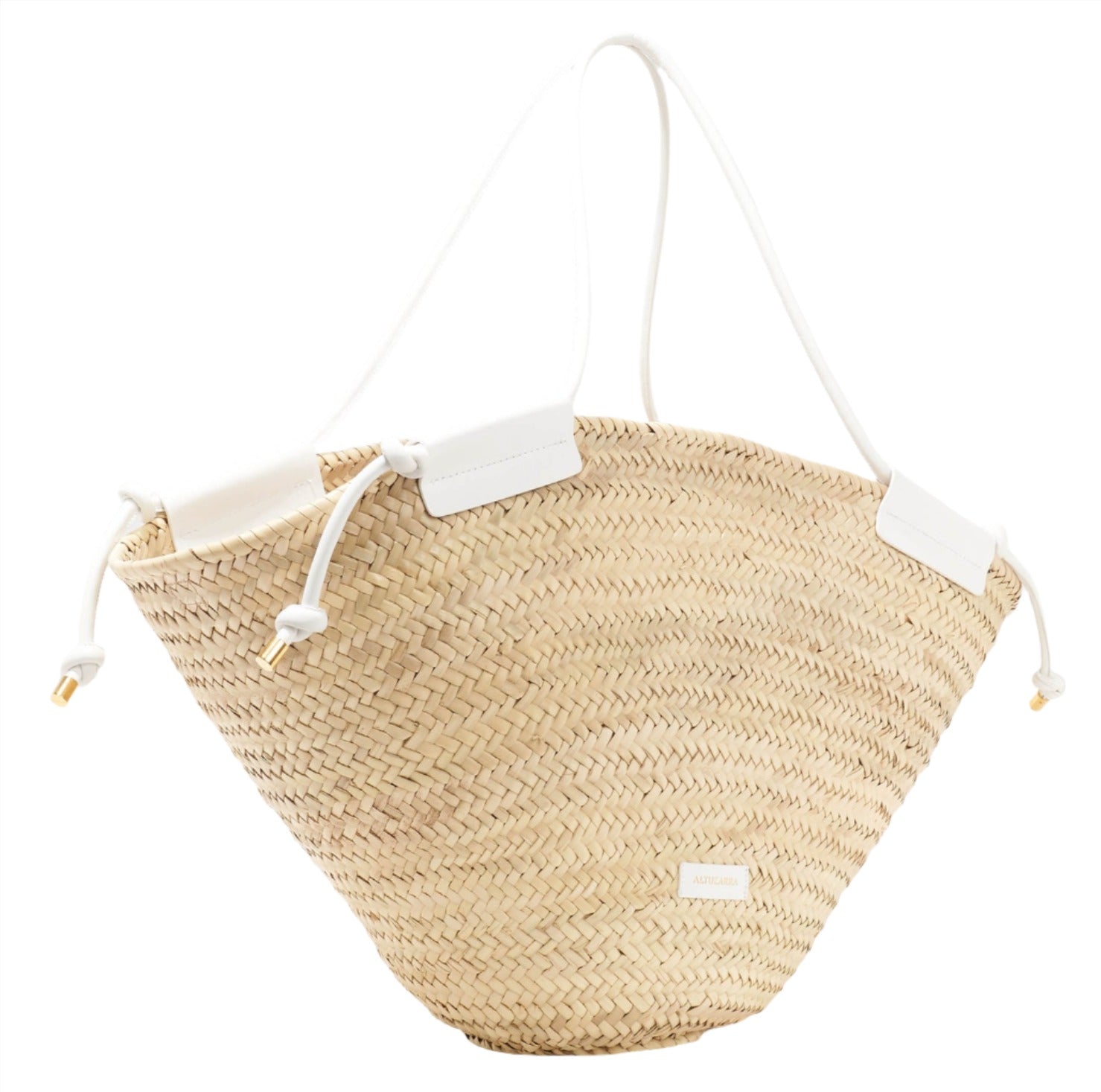 The Altuzarra Basket Tote by Altuzarra is a handmade natural woven straw basket tote that features sleek white leather straps and a convenient drawstring closure.