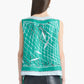 A person with straight brown hair wears the Altuzarra Siggi Top—a sleeveless green top featuring a white and black net pattern and a wide neckline—paired with black leather pants.