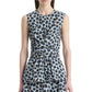 A woman wears the Altuzarra Tizzy Top, a sleeveless blue and black leopard print top with a round neckline, draped waist, and peplum hem, paired with a matching skirt.
