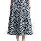 A woman showcasing the Altuzarra Varda Skirt—a high-waisted, A-line midi skirt featuring a blue and black leopard print crafted from soft cotton—pairs it with black strappy sandals for an effortlessly chic look.