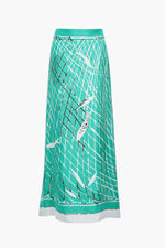 The Linnie Silk Skirt by Altuzarra features a teal A-line silhouette adorned with a black net pattern and white fish illustrations, finished with a contrasting white hem and a fitted waist for an elegant touch.