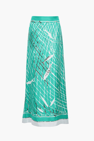 The Linnie Silk Skirt by Altuzarra features a teal A-line silhouette adorned with a black net pattern and white fish illustrations, finished with a contrasting white hem and a fitted waist for an elegant touch.