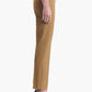 A person is shown in profile wearing the Altuzarra Todd Pant—tan tailored straight-leg pants—paired with black high-heeled sandals against a plain white background.