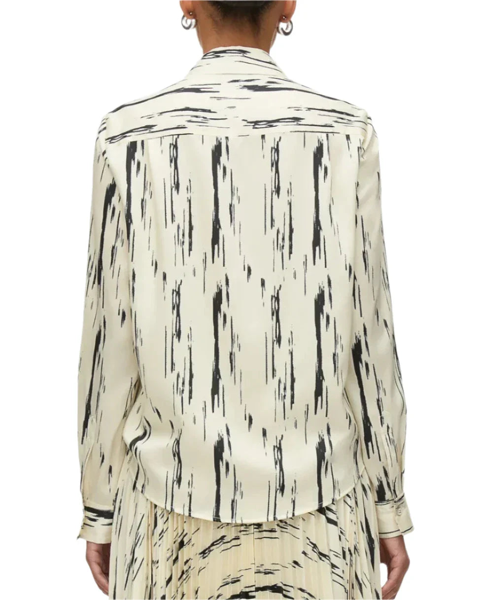 A person wearing a 3.1 Phillip Lim Abstract Wood Grain Crossover Drape Blouse, featuring long sleeves and black abstract wood grain streaks, viewed from the back.