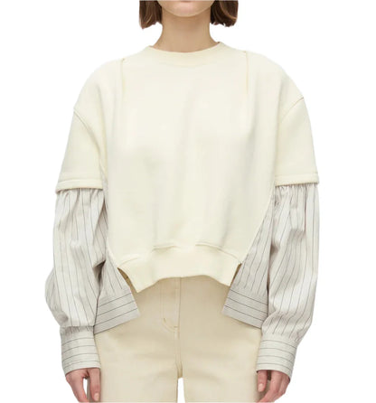 A person wears the 3.1 Phillip Lim Sweatshirt with Poplin Combo in cream organic cotton over a striped shirt, paired with beige pants, against a plain background.