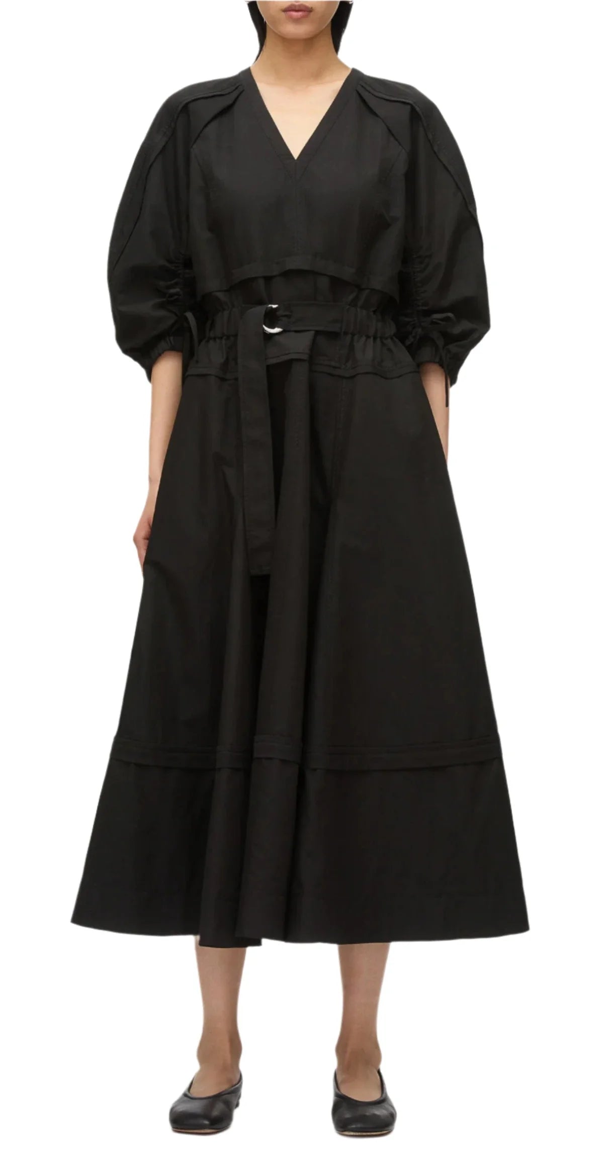 Someone gracefully wears the 3.1 Phillip Lim V Neck Dress with Gathered Sleeves, a sophisticated piece made of luxurious Italian ottoman cotton, cinched at the waist with a belt and complemented by stylish black flats.