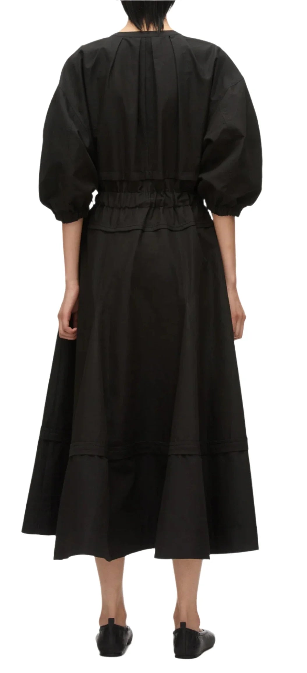 A person is seen elegantly from the back, wearing the 3.1 Phillip Lim V Neck Dress with gathered sleeves, a black, long-sleeved dress featuring belle sleeves and a gathered waist, crafted from luxurious Italian ottoman cotton.