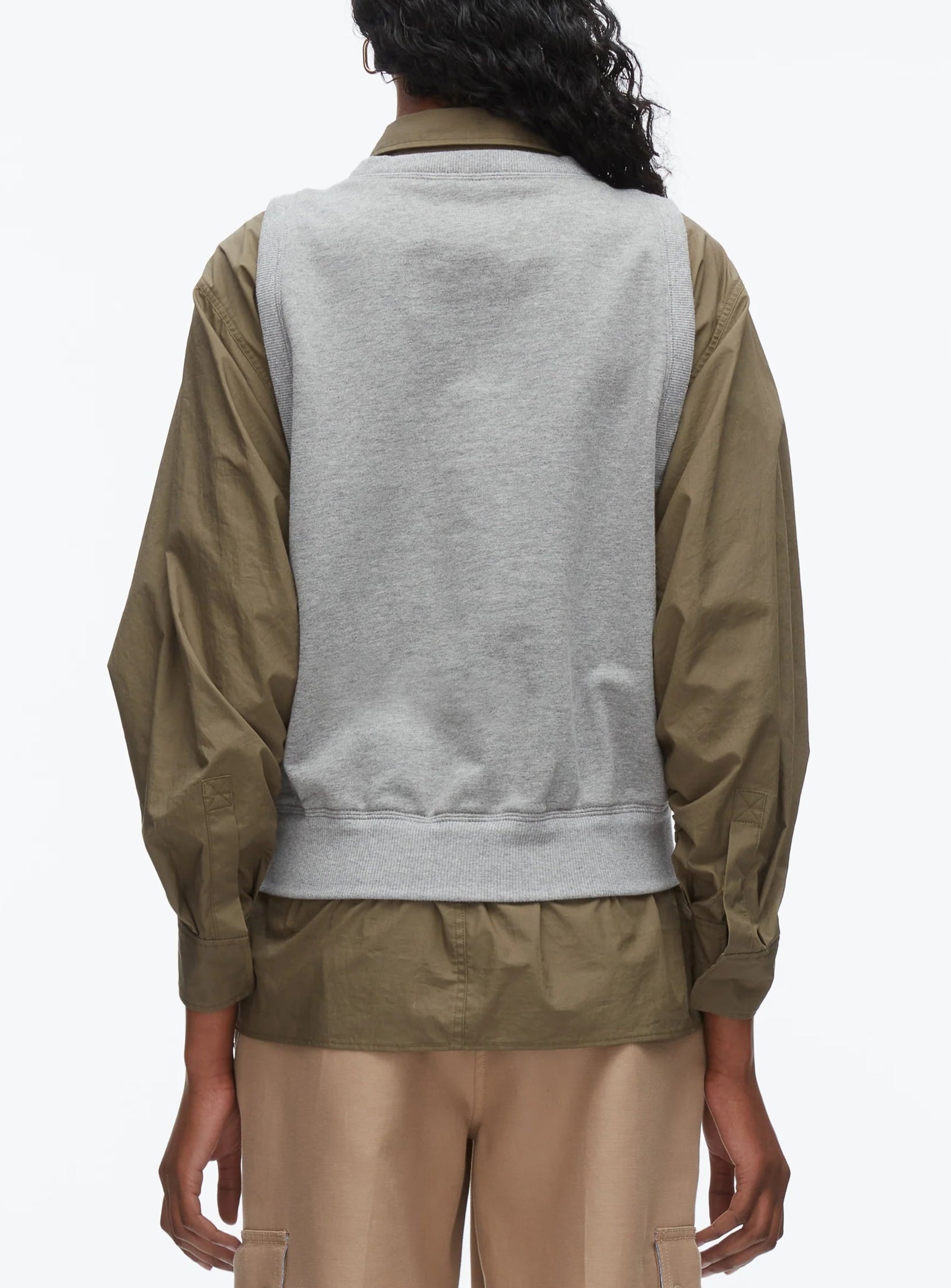 A person is seen from behind wearing the 3.1 Phillip Lim Layered Vest Ruched Sleeve Shirt paired with beige pants, set against a plain background.