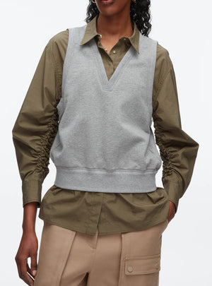 A person wears the 3.1 Phillip Lim Layered Vest Ruched Sleeve Shirt, styled with beige pants featuring large pockets.