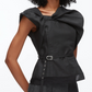 A woman wears the 3.1 Phillip Lim Sleeveless Draped Bow Top w Belt, featuring an oversized shoulder detail and belted waist, paired with grey Italian ottoman weave trousers.