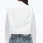 A person is seen from the back wearing a 3.1 Phillip Lim Cropped Shirt with Embroidered Collar, styled with high-waisted blue jeans against a plain background.