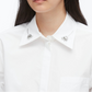 A person wears the 3.1 Phillip Lim Cropped Shirt with Embroidered Collar, crafted from technical poplin and adorned with silver collar embellishments.