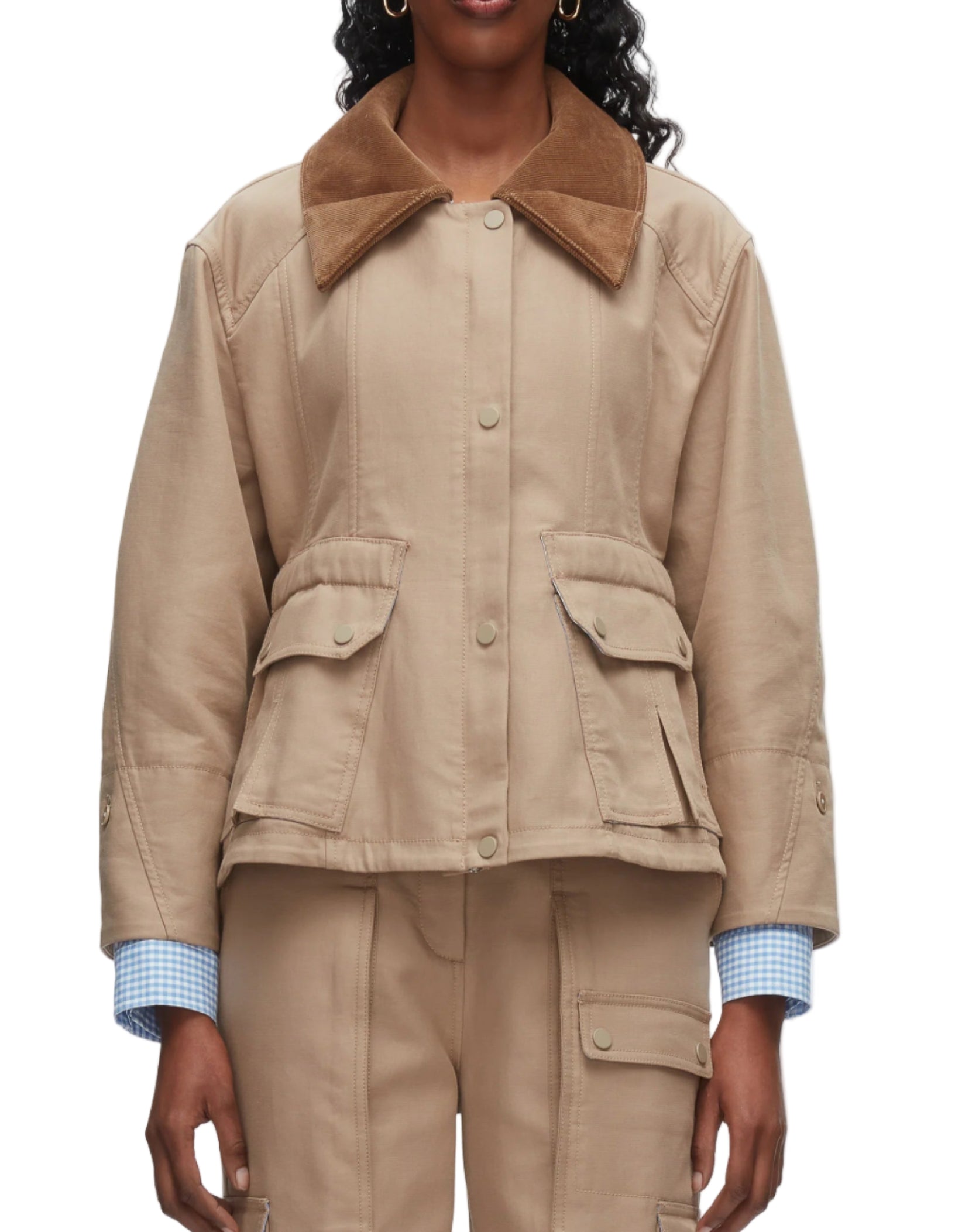 A person wearing the 3.1 Phillip Lim Cropped Flounce Barn Jacket in beige with a brown corduroy collar, flap pockets, and matching beige pants, layered over a light blue checkered shirt.