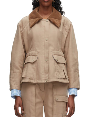 A person wearing the 3.1 Phillip Lim Cropped Flounce Barn Jacket in beige with a brown corduroy collar, flap pockets, and matching beige pants, layered over a light blue checkered shirt.