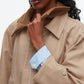 A woman in the 3.1 Phillip Lim Cropped Flounce Barn Jacket with a brown corduroy collar and light blue gingham shirt holds the jacket’s collar.