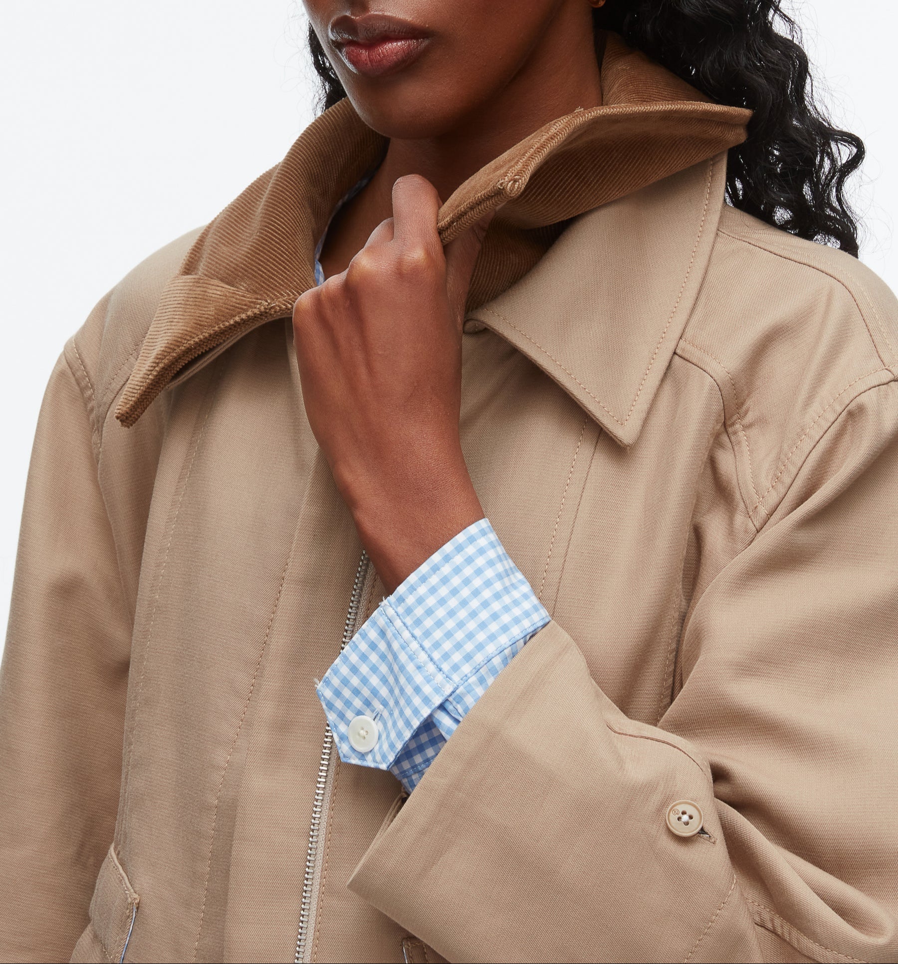 A woman in the 3.1 Phillip Lim Cropped Flounce Barn Jacket with a brown corduroy collar and light blue gingham shirt holds the jacket’s collar.