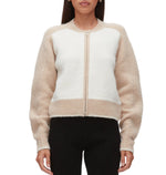 A person wearing the 3.1 Phillip Lim Raglan Zip Cardigan in cream and beige color block with long sleeves and black pants, shown from the front.