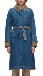 A person wears the 3.1 Phillip Lim Denim Combo Trench, a long blue denim coat with plaid collar and cuffs, removable belt, and mixed-media construction, standing against a white background.