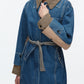 A woman wearing the 3.1 Phillip Lim Denim Combo Trench, which features a removable belt.