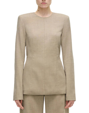 A model wears the Adam Lippes Noa Top in beige Italian tropical wool, a long-sleeve tailored style with removable shoulder pads, paired with matching pants, shown from the front against a plain white background.